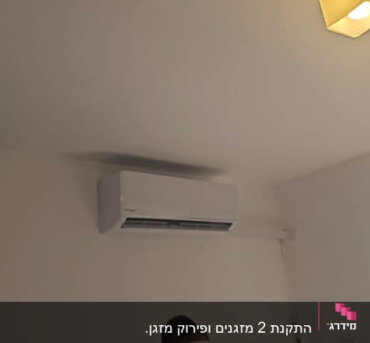 מזגן מותקן על קיר לבן בחדר מואר
